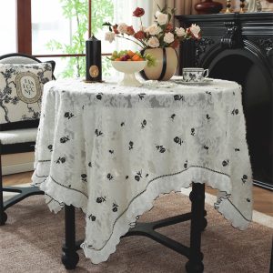 White cotton embroidered tablecloth with lace trim on farmhouse table