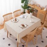 100% cotton floral tablecloth with tassels displayed on wooden dining table