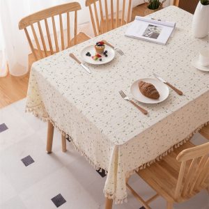 Scandinavian style table setup with beige cotton tablecloth and ceramic dishes