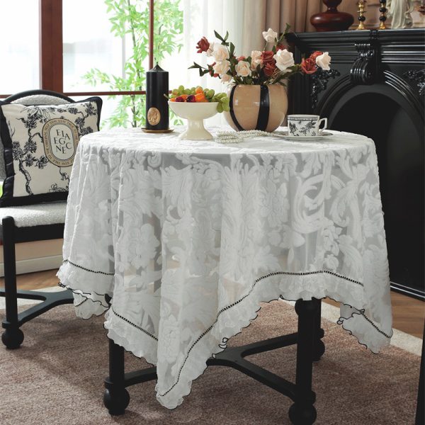 Cotton embroidered tablecloth with lace hem on vintage wood table