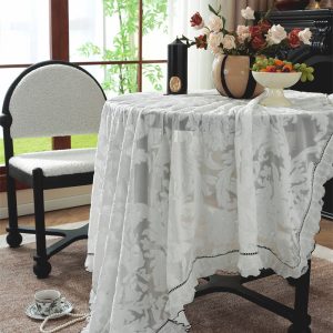 Close-up of floral embroidery and scalloped lace edge