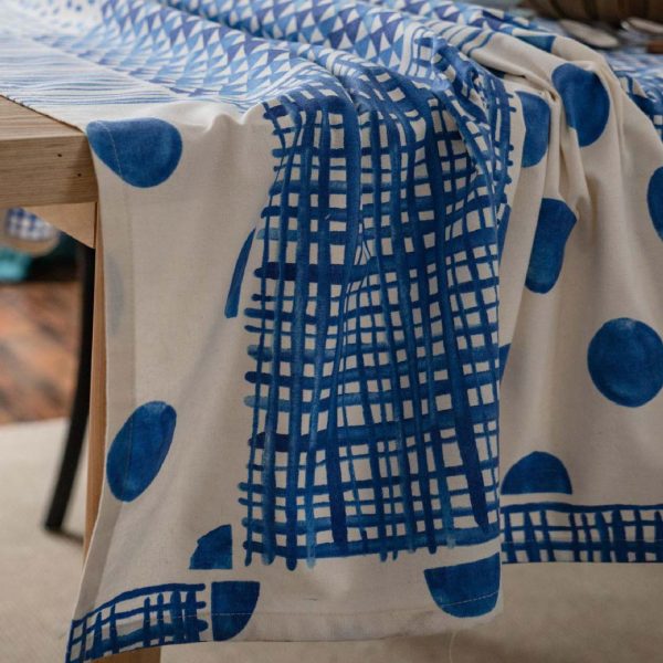 Blue and white geometric cotton-linen tablecloth on a modern dining table, minimalist and elegant style.