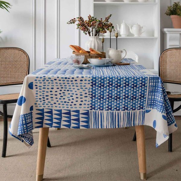 Blue and white geometric cotton-linen tablecloth on a modern dining table, minimalist and elegant style.