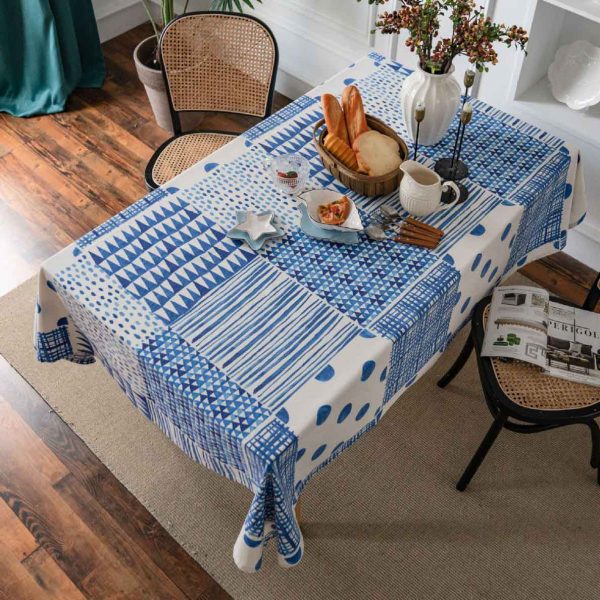 Blue and white geometric cotton-linen tablecloth on a modern dining table, minimalist and elegant style.