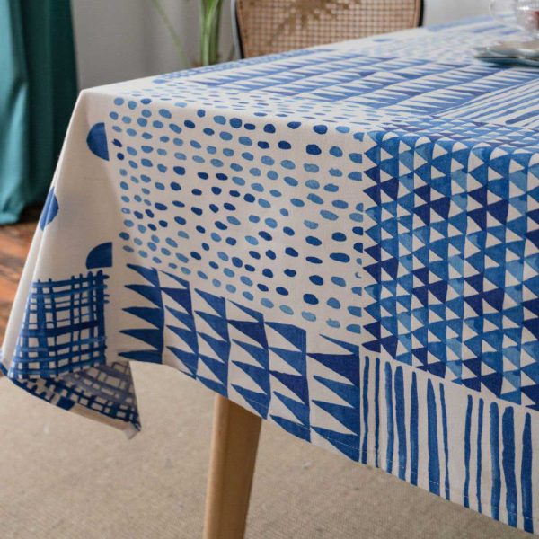 Blue and white geometric cotton-linen tablecloth on a modern dining table, minimalist and elegant style.