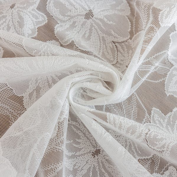 White romantic camellia lace tablecloth used in a cozy garden setting with tea set.