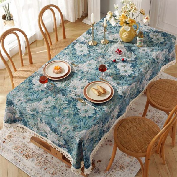 Woven cotton polyester tablecloth with blue daisy floral pattern and tassel trim on beige background – elegant and soft, perfect for dining table settings