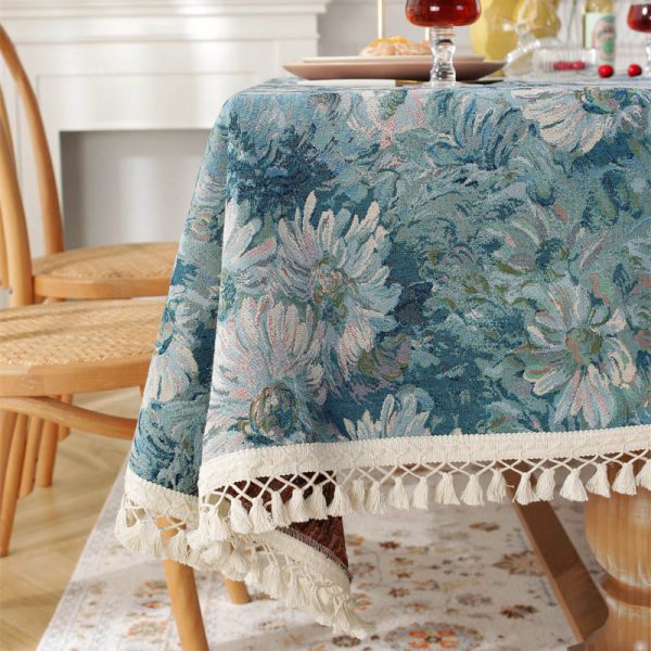 Woven cotton polyester tablecloth with blue daisy floral pattern and tassel trim on beige background – elegant and soft, perfect for dining table settings