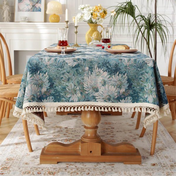 Woven cotton polyester tablecloth with blue daisy floral pattern and tassel trim on beige background – elegant and soft, perfect for dining table settings