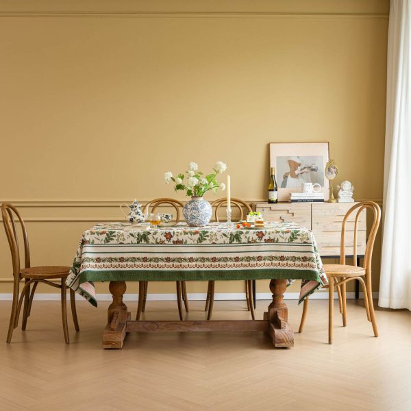 Vintage floral jacquard tablecloth with green border, perfect for rustic or farmhouse-style dining settings