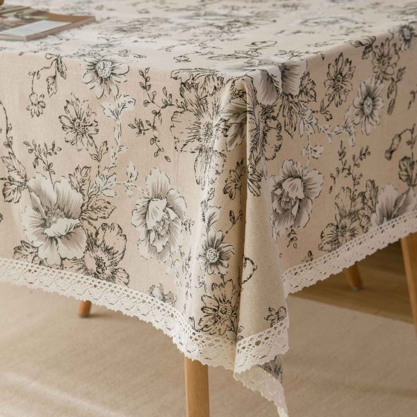 Elegant ivory cotton-linen tablecloth with pink peony floral pattern and white lace trim, styled in a romantic vintage dining setting.
