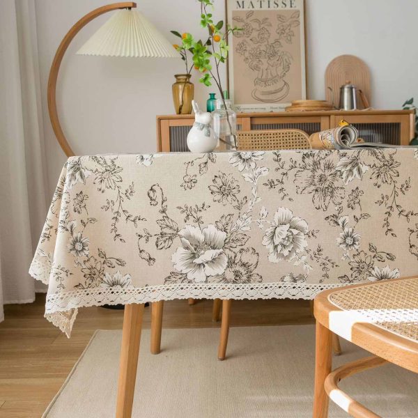 Elegant ivory cotton-linen tablecloth with pink peony floral pattern and white lace trim, styled in a romantic vintage dining setting.