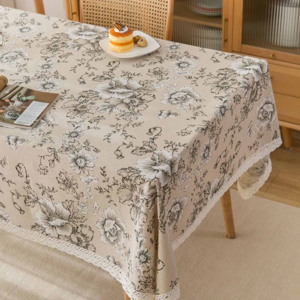 Elegant ivory cotton-linen tablecloth with pink peony floral pattern and white lace trim, styled in a romantic vintage dining setting.
