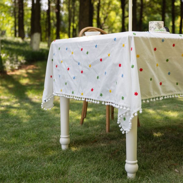 Cotton embroidered tablecloth with colorful floral embroidery and pom-pom edging, ideal for dining tables. Soft cotton blend material, perfect for home dining and special occasions.
