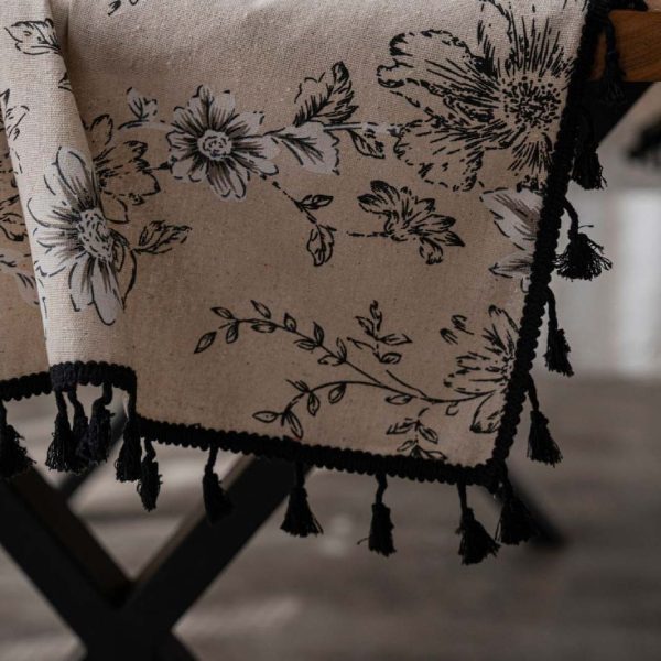 Beige floral cotton-linen tablecloth with black lace and tassels, styled in an elegant boho dining setup. Soft texture with vintage charm.