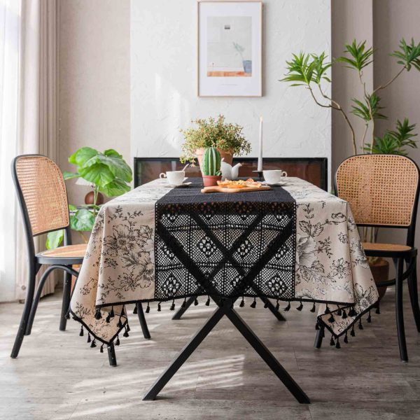Beige floral cotton-linen tablecloth with black lace and tassels, styled in an elegant boho dining setup. Soft texture with vintage charm.