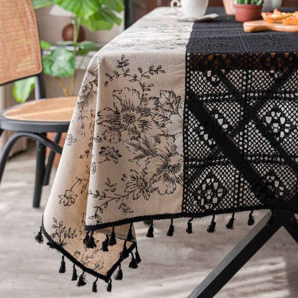Beige floral cotton-linen tablecloth with black lace and tassels, styled in an elegant boho dining setup. Soft texture with vintage charm.