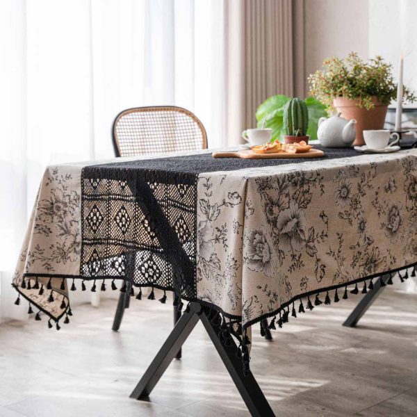 Beige floral cotton-linen tablecloth with black lace and tassels, styled in an elegant boho dining setup. Soft texture with vintage charm.