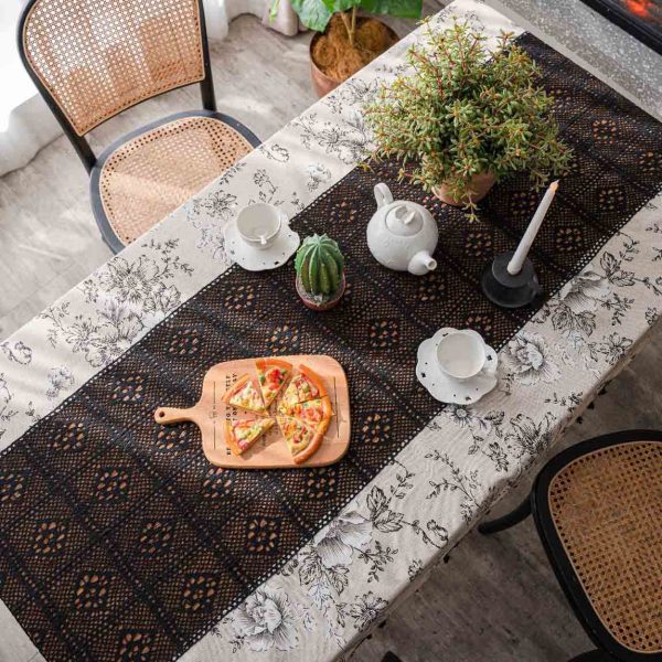 Beige floral cotton-linen tablecloth with black lace and tassels, styled in an elegant boho dining setup. Soft texture with vintage charm.