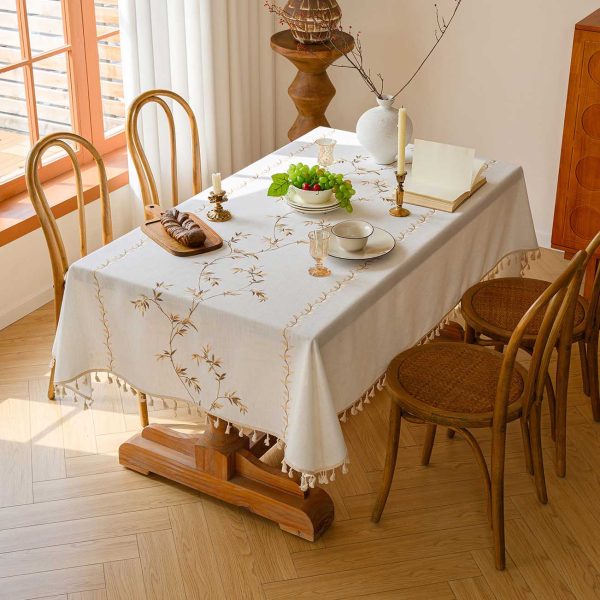 Bamboo leaf embroidered faux linen tablecloth on a wooden dining table