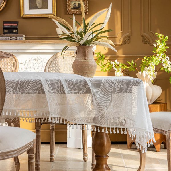 White polyester tablecloth with soft banana leaf print, lace trim, and tassel edge—styled for modern botanical or farmhouse dining.