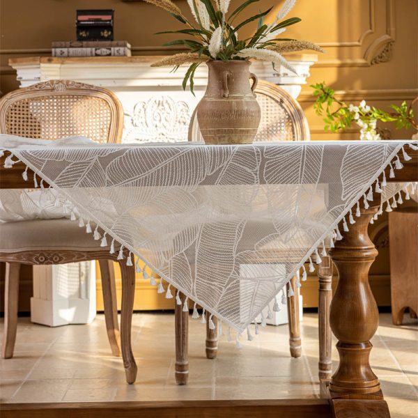 White polyester tablecloth with soft banana leaf print, lace trim, and tassel edge—styled for modern botanical or farmhouse dining.