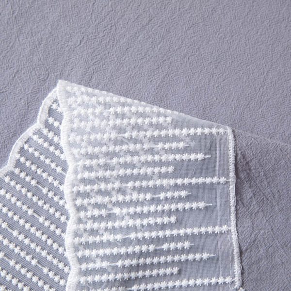 Elegant purple-gray cotton tablecloth with scalloped meteor edges, draped over a modern dining table with natural lighting and minimalist decor.