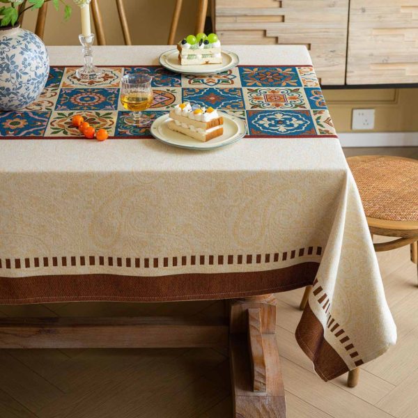 Beige cotton blend tablecloth with Moroccan tile pattern and brown border, featuring jacquard texture and soft tassels – ideal for rustic and bohemian dining rooms.