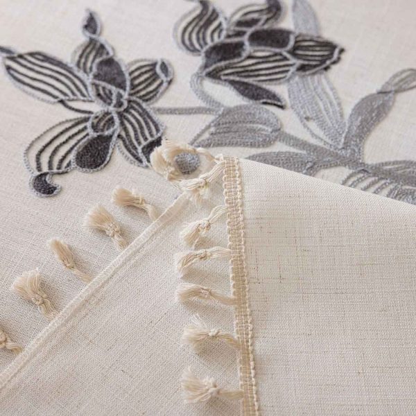 Close-up of gray flower embroidery on white polyester tablecloth
