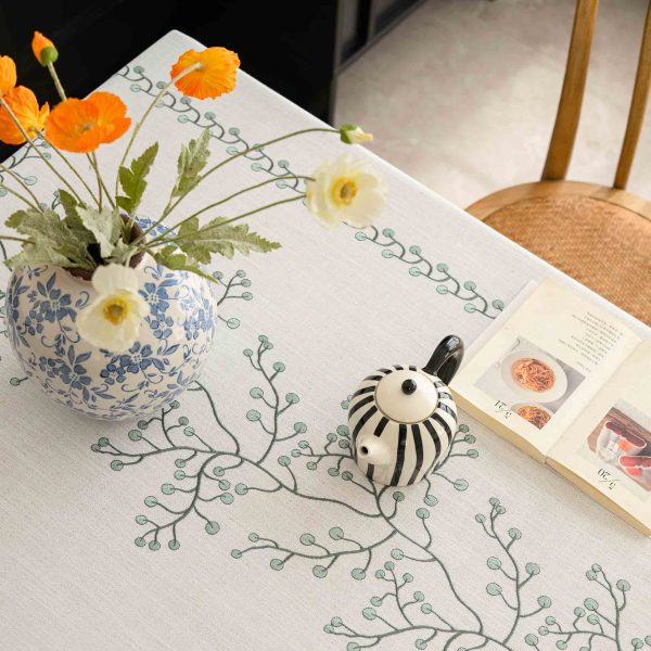 Outdoor dining setup using oval embroidered tablecloth with fringe edges