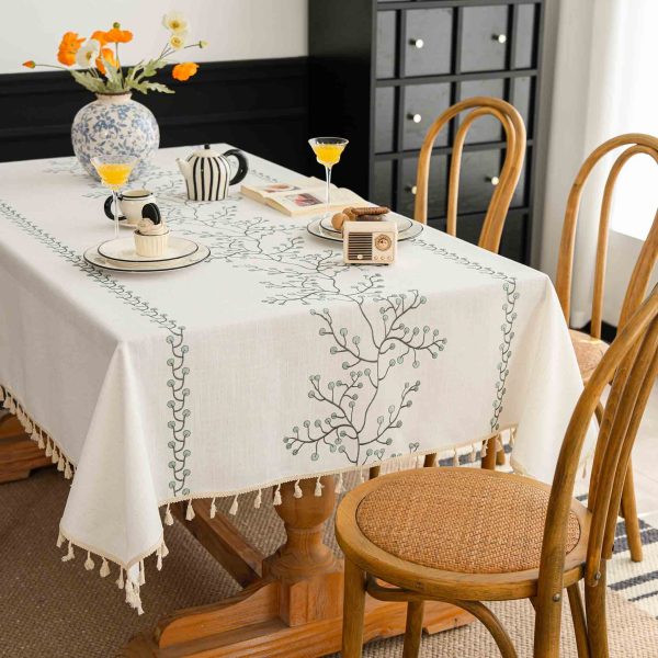 Elegant embroidered faux linen tablecloth with green berry design on a white background
