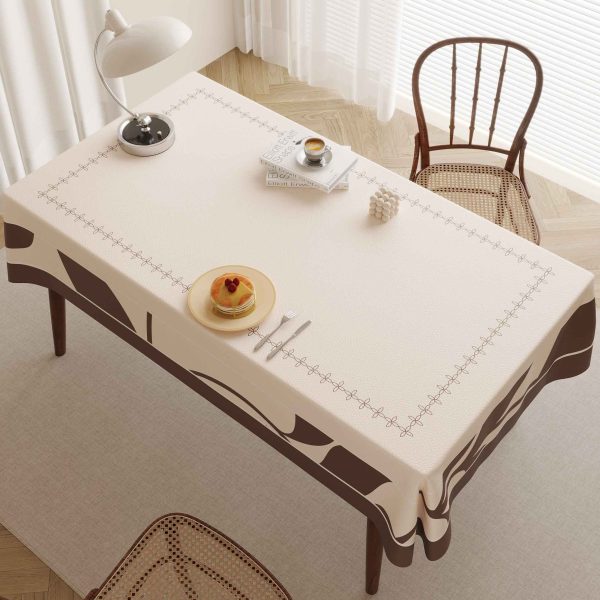 Oilcloth tablecloth in beige and brown tones laid out on a cozy patio setting