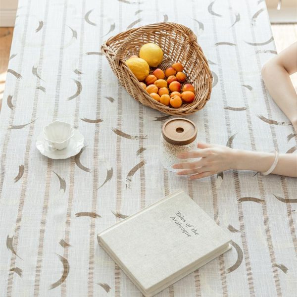 Beige polyester tablecloth with blue floral embroidery and tassel fringe, styled on a farmhouse dining table