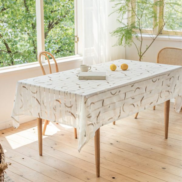Beige polyester tablecloth with blue floral embroidery and tassel fringe, styled on a farmhouse dining table