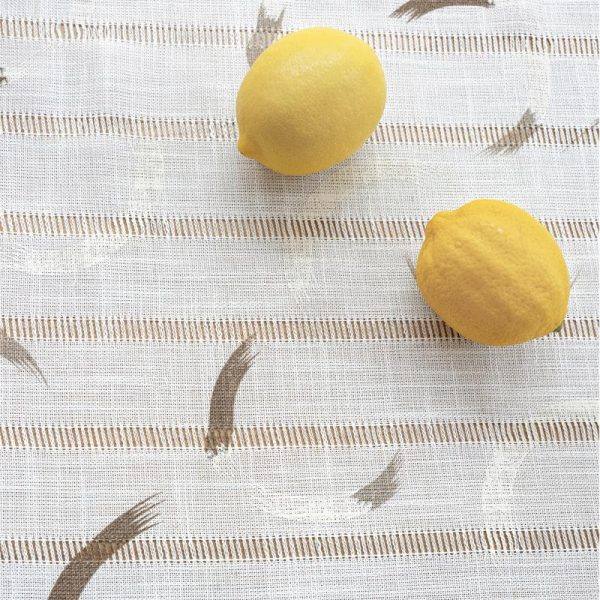 Beige polyester tablecloth with blue floral embroidery and tassel fringe, styled on a farmhouse dining table