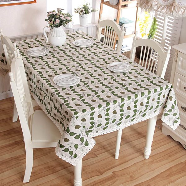 Poly-cotton tablecloth with green leaf print and delicate lace trim, featuring a soft and cozy farmhouse style. Ideal for everyday dining, outdoor meals, or family gatherings.