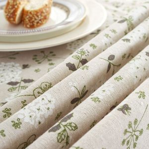 Vintage floral cotton-blend tablecloth with lace trim on wooden dining table