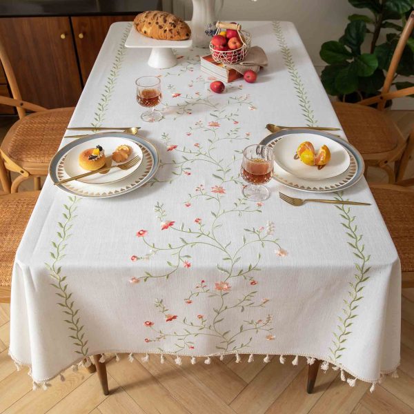 Washable pink embroidered tablecloth used as a picnic table cover outdoors