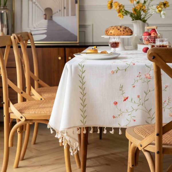 Reusable table cover protecting a wooden dining table with French country charm