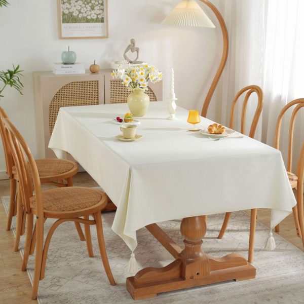Faux linen kitchen table protector styled with ceramic plates and flowers