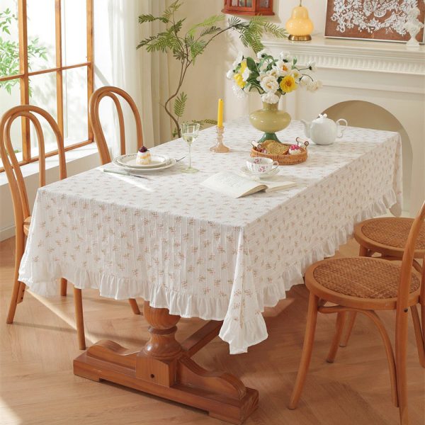 Cotton tablecloth with tulip floral print and ruffled edges, styled in a cottage-inspired dining room with soft lighting and rustic wooden accents.