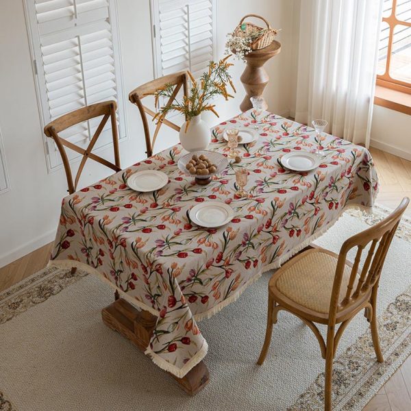 Rectangle tablecloth with romantic floral design, laid over a wooden dining table