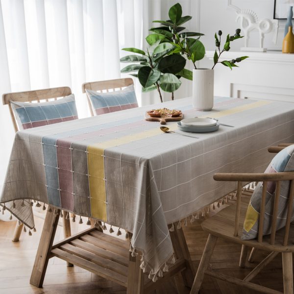 Gray faux linen tablecloth with colorful stripes and tassel fringe edges, ideal for modern dining rooms, outdoor use, or casual restaurant settings.