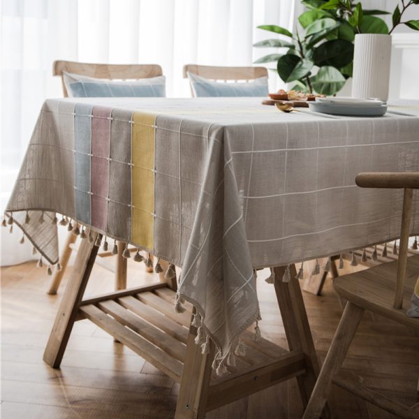 Gray faux linen tablecloth with colorful stripes and tassel fringe edges, ideal for modern dining rooms, outdoor use, or casual restaurant settings.