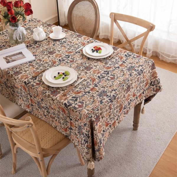 Vintage-style tablecloth featuring colorful floral and bird patterns, woven in a cotton-blend fabric with elegant tassel trim, perfect for farmhouse or cottage-style dining settings.
