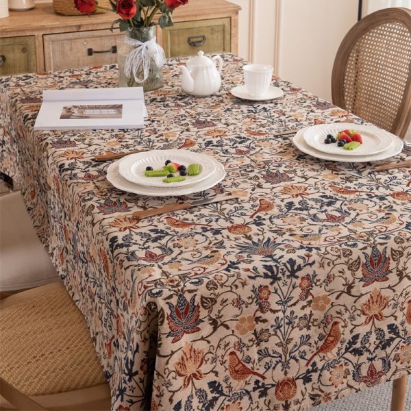 Vintage-style tablecloth featuring colorful floral and bird patterns, woven in a cotton-blend fabric with elegant tassel trim, perfect for farmhouse or cottage-style dining settings.