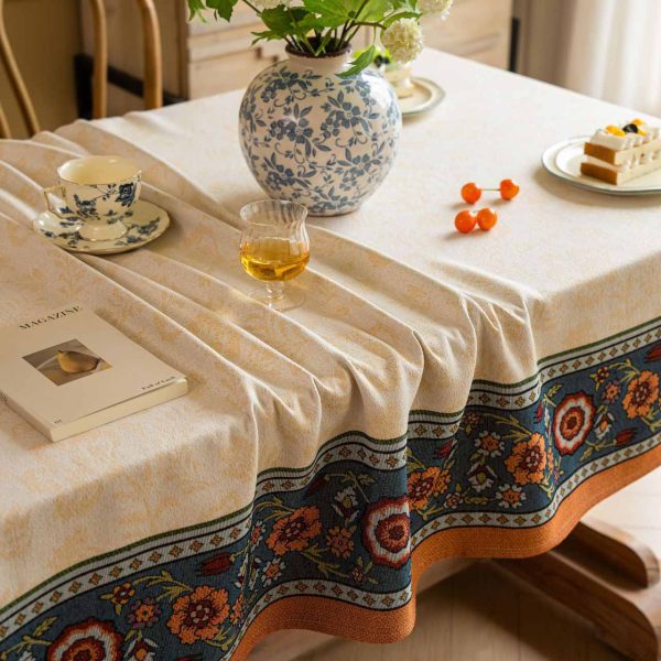 Vintage floral jacquard tablecloth in warm tones with decorative Nordic-style border, perfect for rustic or elegant dining setups.