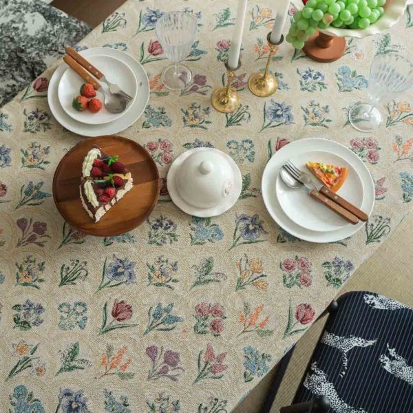 Elegant hyacinth floral jacquard tablecloth in soft beige with curved botanical design and textured finish, styled on a wooden dining table with natural light.