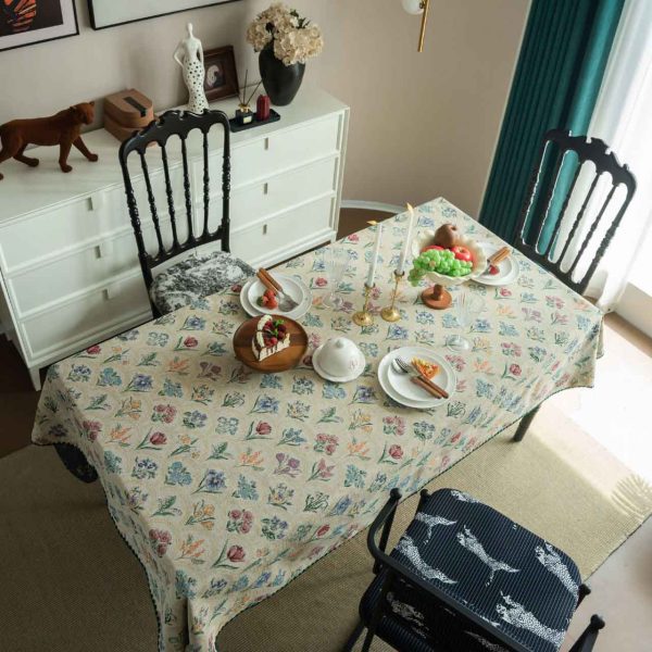 Elegant hyacinth floral jacquard tablecloth in soft beige with curved botanical design and textured finish, styled on a wooden dining table with natural light.