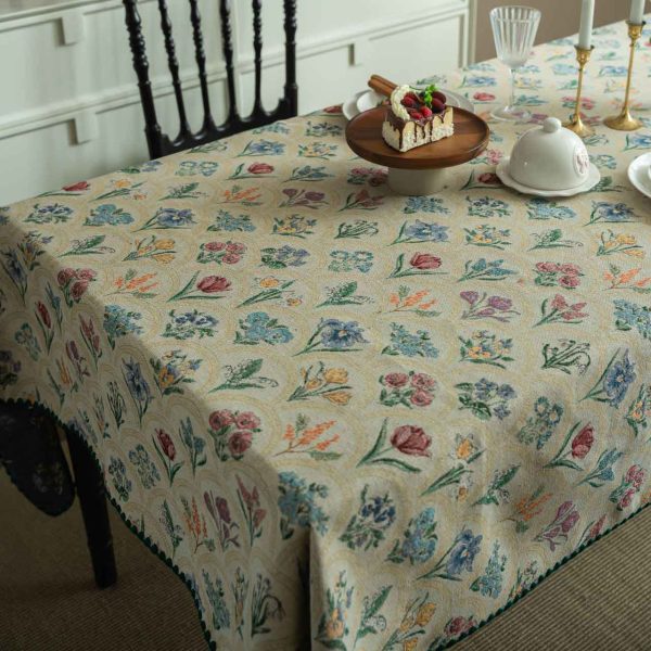 Elegant hyacinth floral jacquard tablecloth in soft beige with curved botanical design and textured finish, styled on a wooden dining table with natural light.